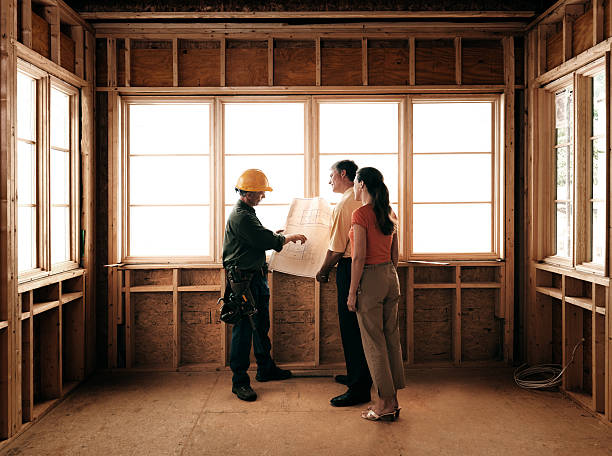 Husband and wife consulting with architect inside a home under construction - Oracle Consulting